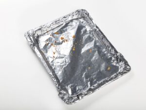 Brudna folia aluminiowa na kuchennym blacie – gotowa do segregacji